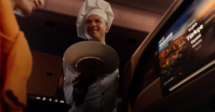 Chef de a bordo sirviendo un plato en la cabina de un avión de Turkish Airlines