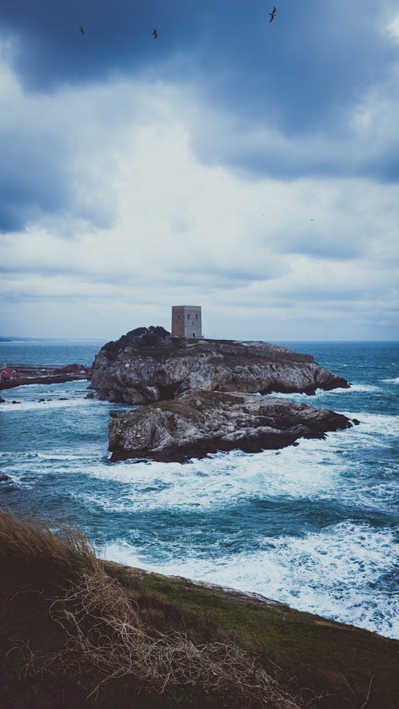 A castle on the coast with waves crashing in the background